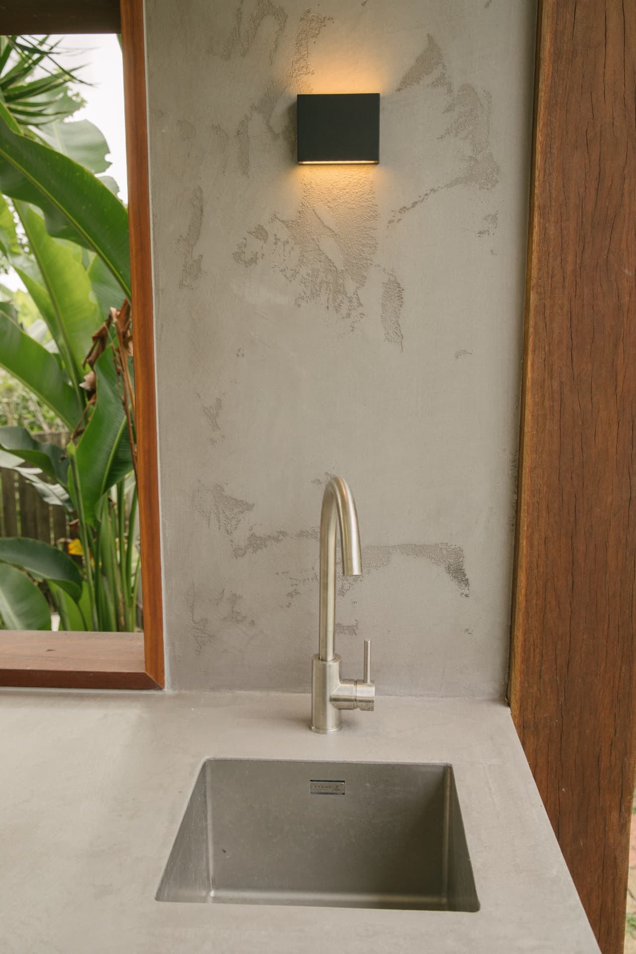 Stainless sink set into concrete against hand-trowelled Venetian plaster
