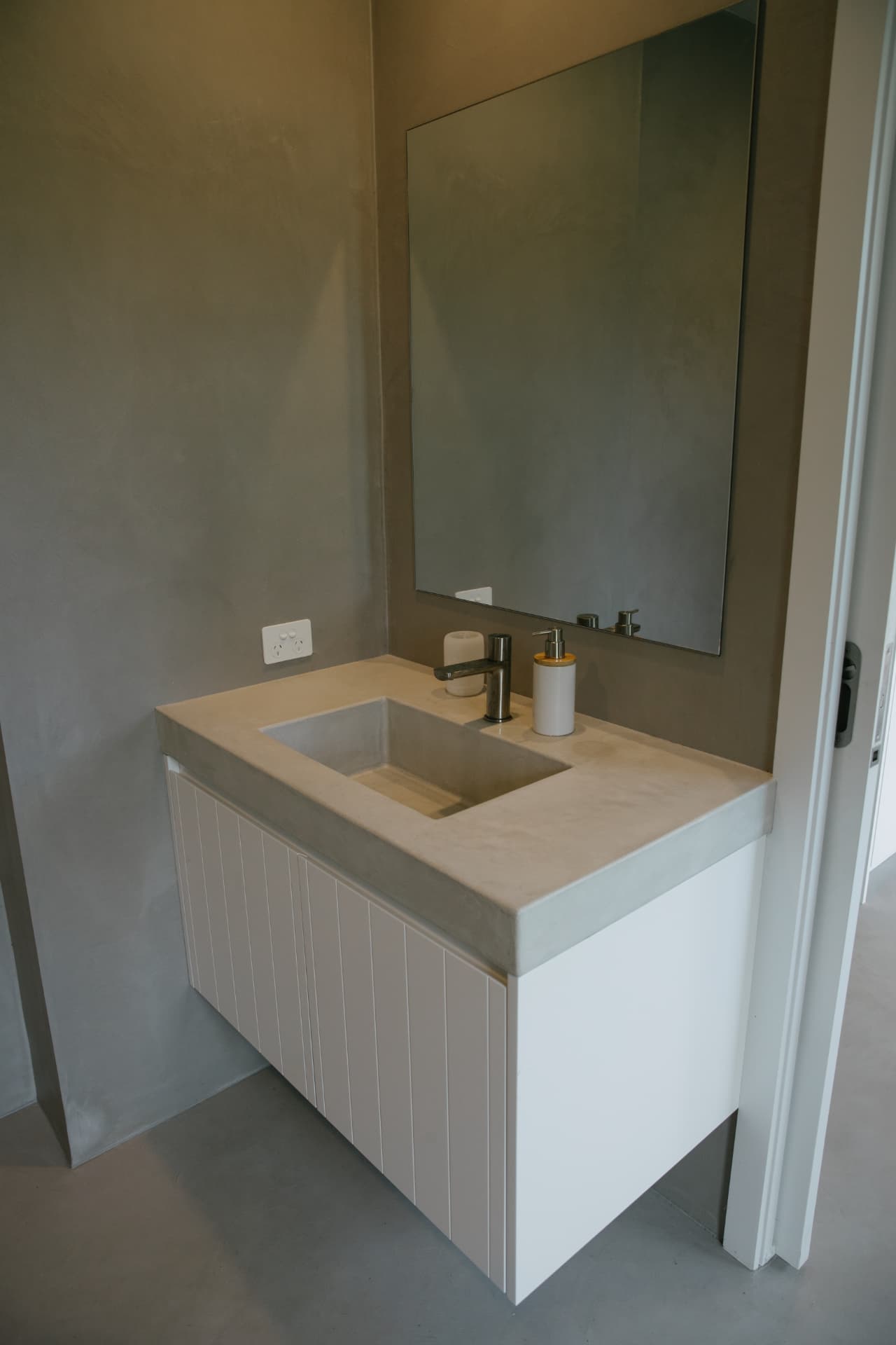 Floating vanity with a cast concrete top and integrated basin